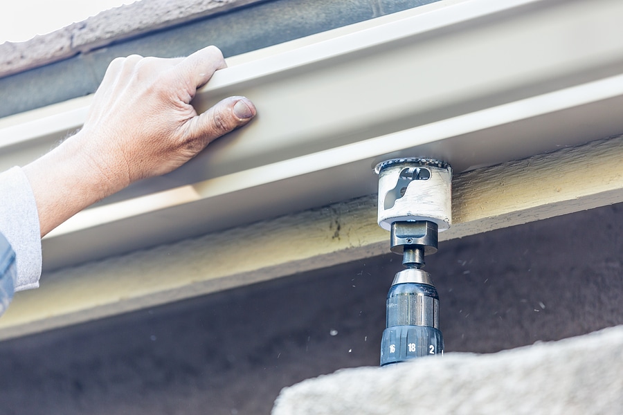 Worker Attaching Aluminum Rain Gutter to Home